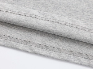 Detail of flat double-needle stitching on light grey cotton knit off-shoulder tee