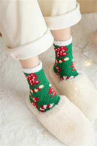 Détail de chaussettes épaisses en polaire corail verte avec motifs de sapins de Noël