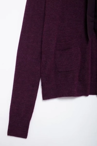 Détail du cardigan en maille violet foncé avec coutures de poche et ruban d'encolure
