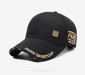 Detail of black baseball cap featuring gold letter embroidery and a square metal badge