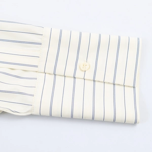 Detailed close-up of striped shirt cuff with a white button and blue pinstripe pattern