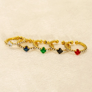 Detail of adjustable gold rings with colorful square zircons in five vibrant gemstone colors