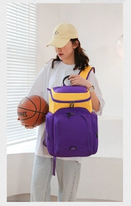 Action shot of a purple and yellow large sports backpack held by a model with a basketball