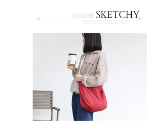 Detail view of large red canvas shoulder bag with minimalist artistic texture and strap