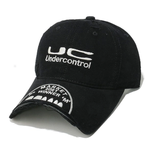 Detailed close-up of vintage distressed black cotton cap with white letter embroidery
