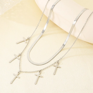 Detail of silver double-layered necklace featuring snake chain and five cross pendants