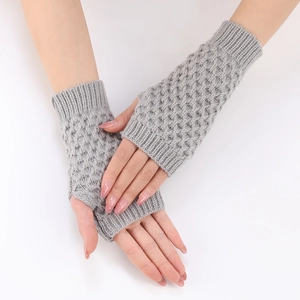 Close-up of grey cable-knit fingerless gloves showing diamond pattern and ribbed cuffs