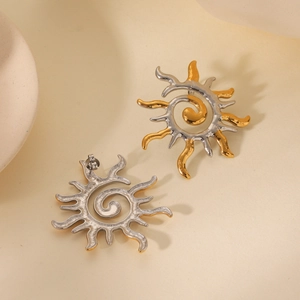 Détail macro de boucles d'oreilles spirales en forme de soleil au fini bicolore or et argent