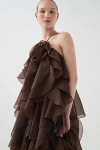 Dettaglio dell'abito marrone con ruches a strati in chiffon e scollo con fiori in 3D