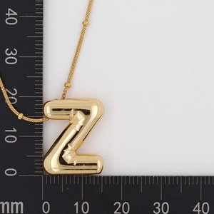 Detail view of gold puffy letter Z balloon pendant with scale ruler showing 25mm size