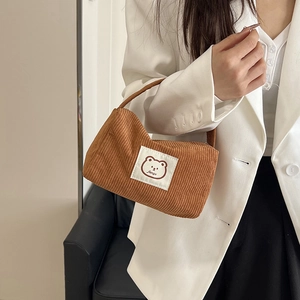 Minimalist brown corduroy handbag featuring a cute bear patch and soft fabric texture