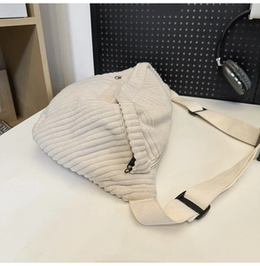 Detail of adjustable strap and buckle on cream corduroy crossbody chest bag