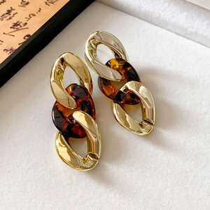 Detail view of retro hollow waterdrop earrings with gold links and amber resin pieces
