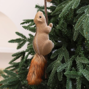 Detail of plush foam squirrel ornament with a fluffy tail on a green Christmas tree