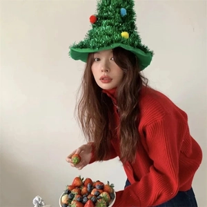 Knitted Christmas tree hat with colorful pom-poms worn by a model in a red sweater