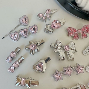 Flat lay view of silver alloy hair clips set with pink crystal star and heart details