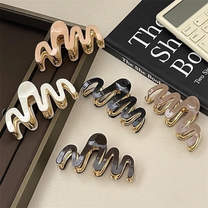 Elegant wave-shaped acetate and metal hair claws in five neutral colors for women