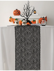 Detail of black lace Halloween table runner featuring intricate spider and web patterns