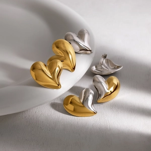 Polished 18K gold and silver heart-shaped stud earrings set in a premium minimalist style
