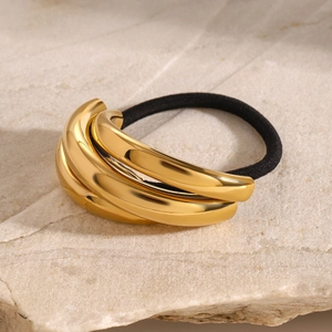 Macro detail of gold curved metal accents on a black elastic ponytail hair tie