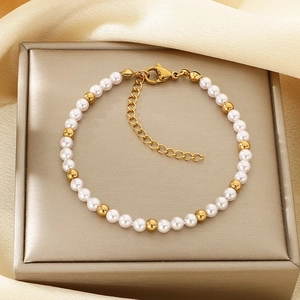 Detailansicht des Perlenarmbands mit Goldperlen auf Seide und goldener Schmuckschachtel