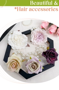 Close-up of five floral pearl hair ties in assorted colors on a beige fabric background