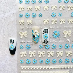 Macro detail of 5D embossed nail stickers featuring blue daisies and lace on sample tips