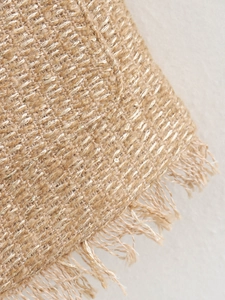 Detaillierte Makroaufnahme von strukturiertem Tweed-Stoff mit Glanzfäden und Fransensaum