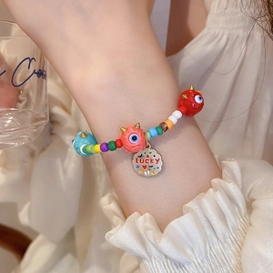 Close-up of colorful beaded bracelet with lucky charm and monster eye pendants