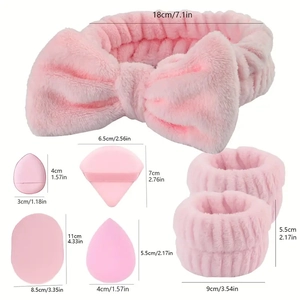 Pink makeup set with velvet bow headband, wristbands, and various sponge puffs on white