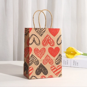 Close-up of thick kraft paper gift bag with red and black heart prints and paper rope handles