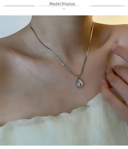 Close-up of a silver avocado shell pendant necklace on model's neck for elegant look