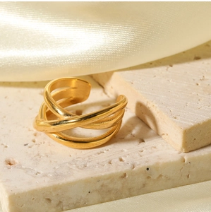 Detailed view of 18K gold-plated multilayer crisscross ring on silk and stone base