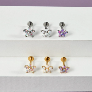 Detailed view of floral opal labret studs in silver and gold tones on a display
