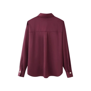 Elegante blusa de satén rojo vino con botones dorados y silueta trasera refinada