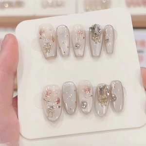Handmade cat eye press-on nails with 3D rose and bow designs on nude pink base