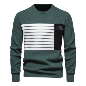 Detailed view of dark green waffle knit texture and chest stripes on men's crewneck sweater