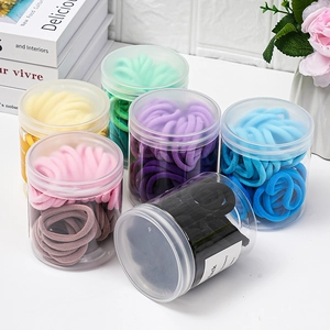 Six jars of multi-color thick elastic hair ties in a bright lifestyle setting
