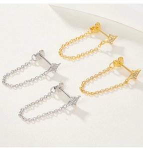Detail shot of gold and silver chain star earrings with sparkling zircon accents
