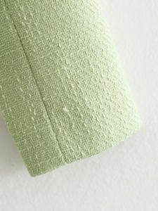 Macro detail of mint green tweed fabric texture for women's autumn casual jacket