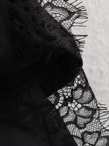 Close-up detail of high-density black eyelash lace trim on a short sleeve t-shirt