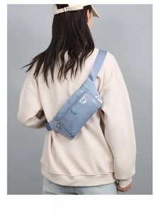 Back view of model wearing a light blue oxford fabric waist bag with multi-compartments