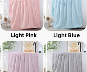 Macro detail of textured coral fleece bath towels in pastel pink, blue, purple, and gray
