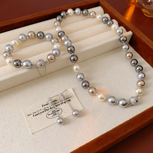 Detailed close-up of a multi-color pearl jewelry set with magnetic pave clasps on a tray