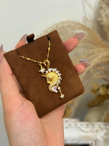 Close-up of 18k gold plated unicorn pendant necklace with pink and white zircon crystals