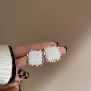 Macro shot of silver square earrings with micro-inlaid rhinestones and white inlay