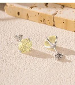 Detail of S925 silver earrings with yellow round-cut crystals in a four-prong setting