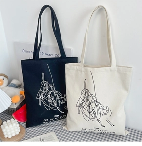 Detail of artistic cat graffiti pattern on black and cream canvas tote bags