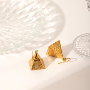 Macro shot of 18K gold-plated pyramid earrings with hieroglyphic texture and vintage style