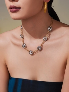 Détail d'un collier Marina bicolore or et argent avec des boucles d'oreilles texturées